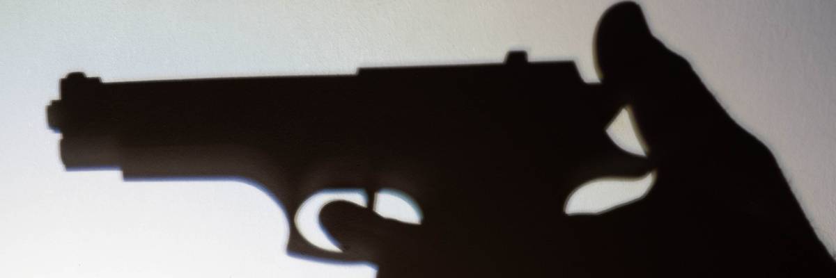 Silhouette of a person that is to shoot with a gun.