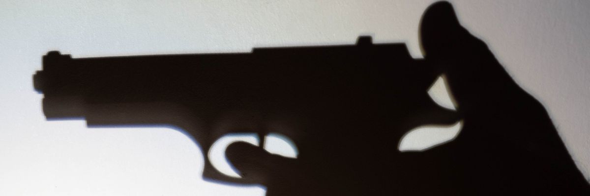 Silhouette of a person that is to shoot with a gun.