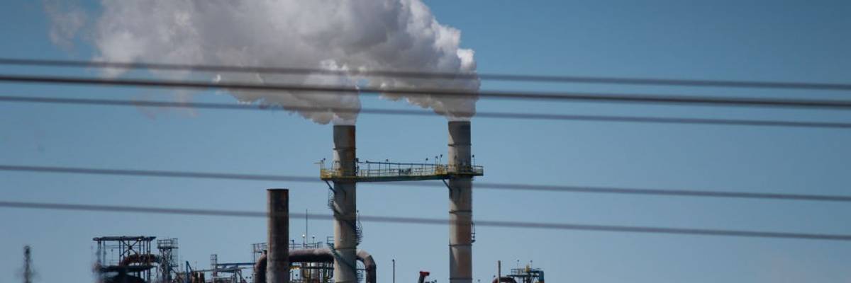 Smoke comes out of a power plant chimney.