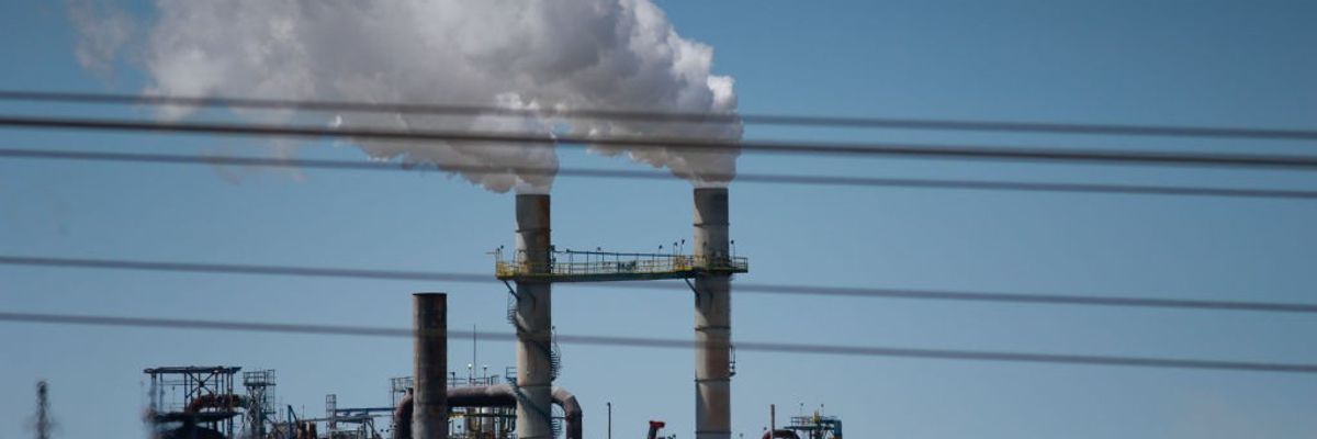 Smoke comes out of a power plant chimney.