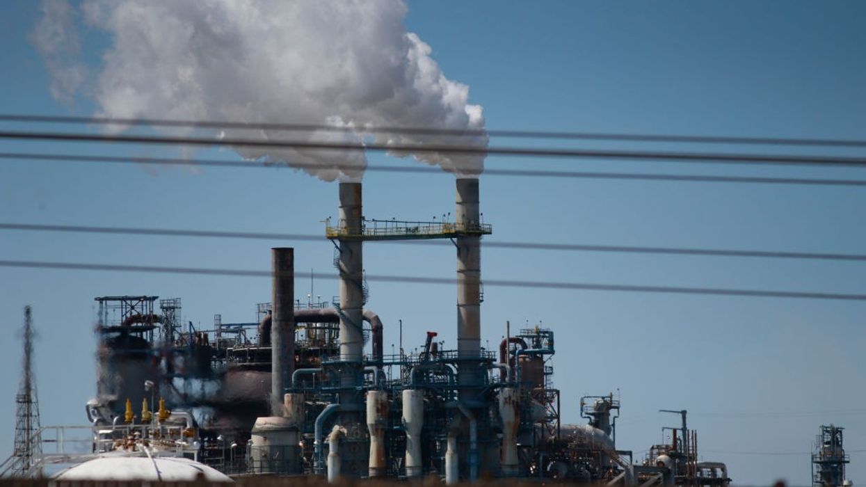 Smoke comes out of a power plant chimney.