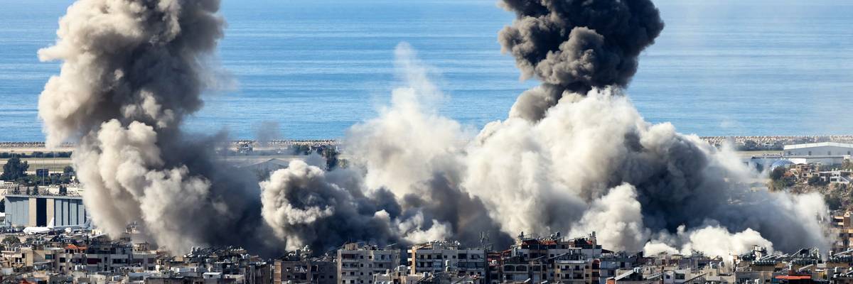 Smoke from airstrikes rises above buildings.