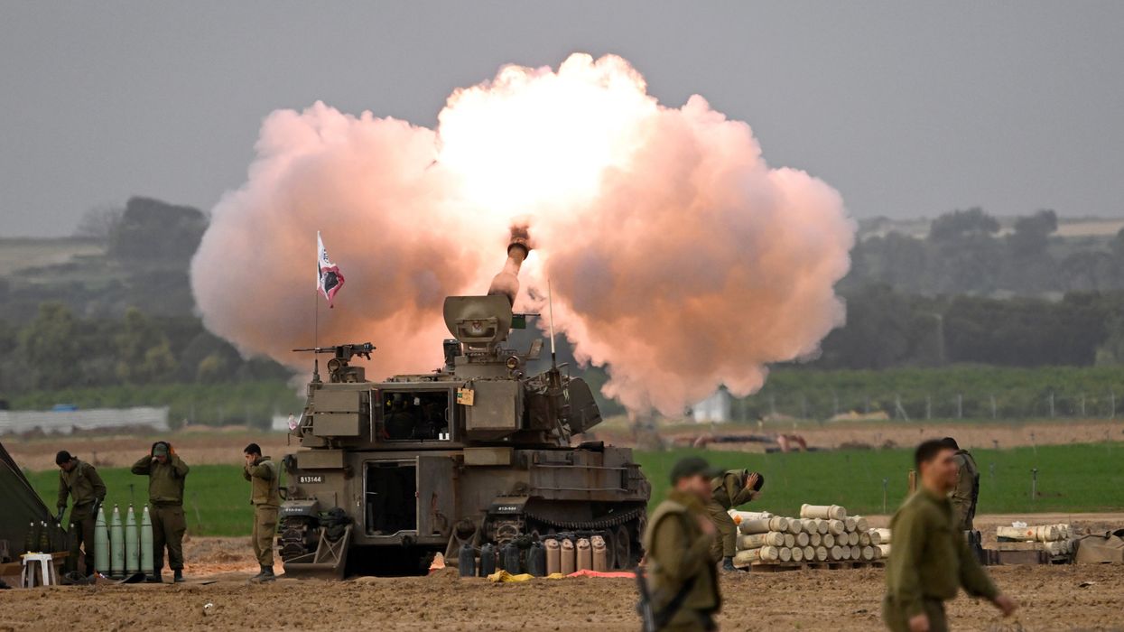 Smoke rises around Israeli artillery units and howitzers