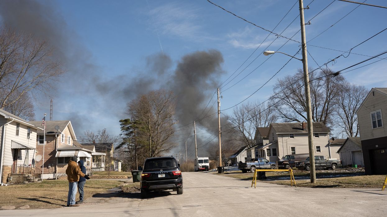 Smoke rises from a derailed cargo train