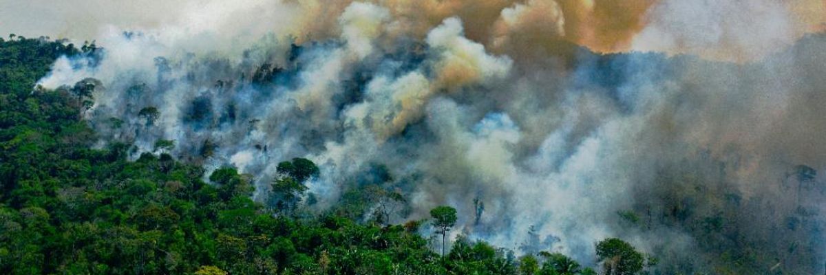 Smoke rises from the Amazon rainforest.