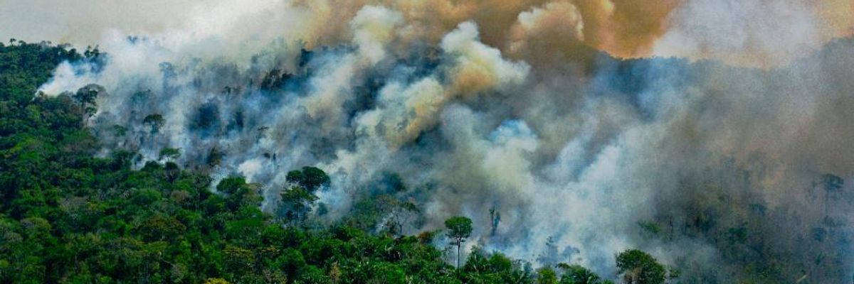 Smoke rises from the Amazon rainforest. 