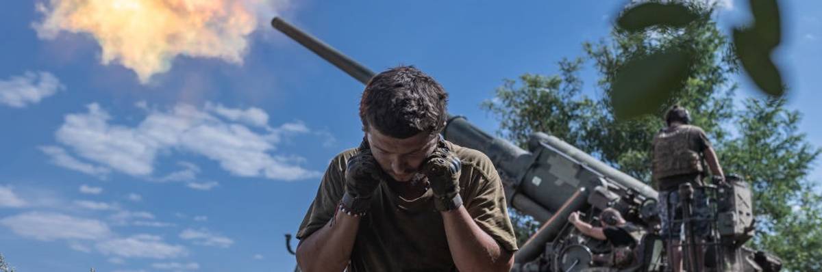Soldier covers ears during artillery fire in Ukraine