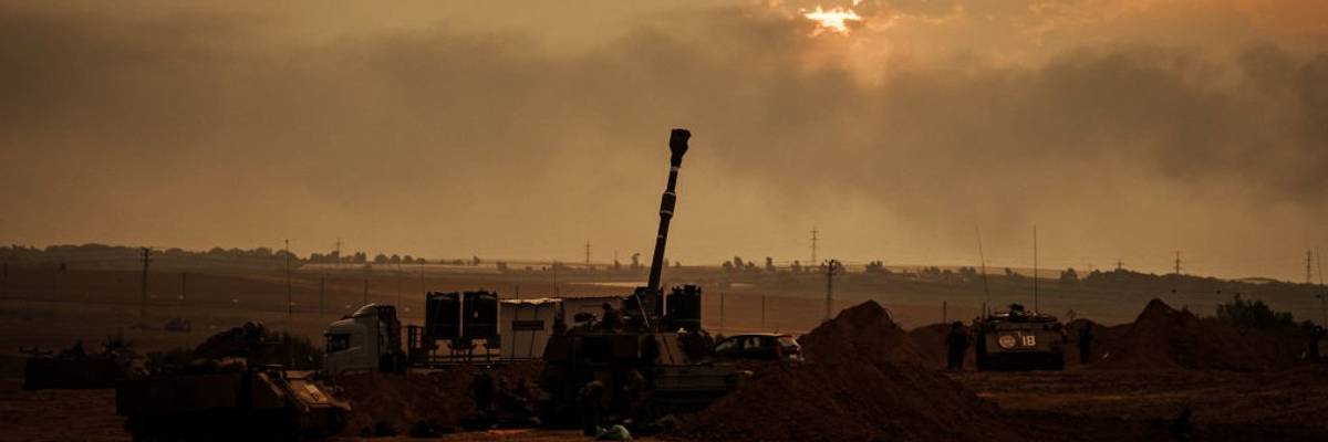 Soldiers from an artillery unit stand in front of a gunsmoke-polluted sky.