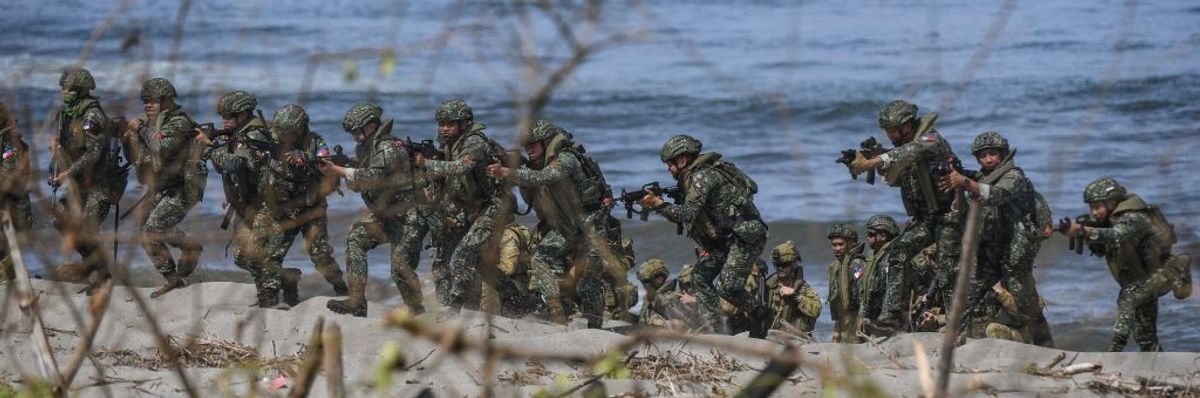 Soldiers take position on a beach.