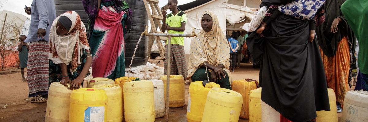 Somali refugees put water in containers