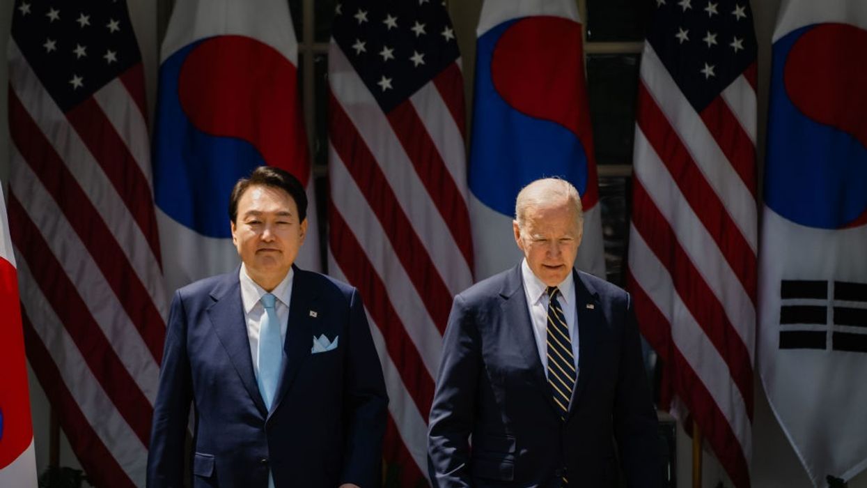 South Korean President Yoon Suk Yeol and President Joe Biden stand in front of flags.
