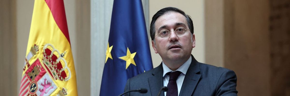 Spain foreign minister speaking at lectern