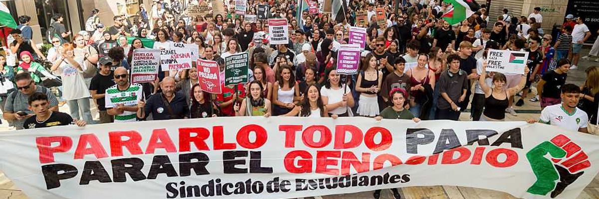 Spanish students march with a banner reading "stop everything to stop the genocide"