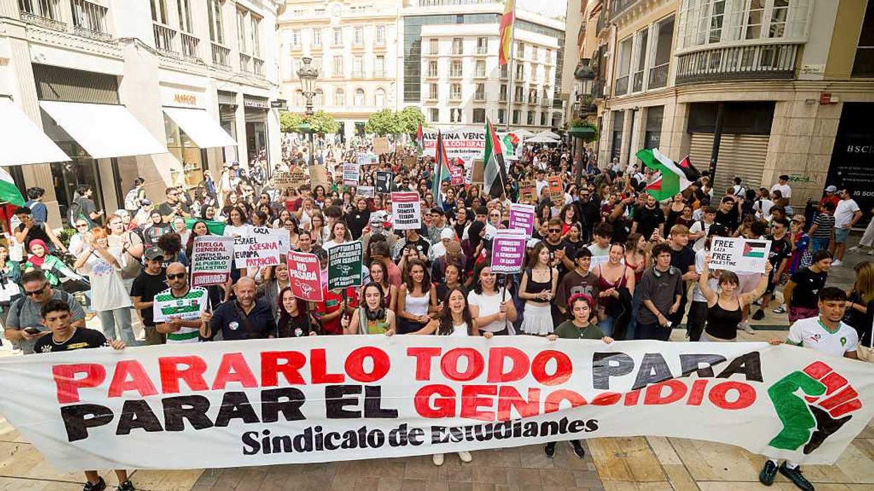 Spanish students march with a banner reading "stop everything to stop the genocide"
