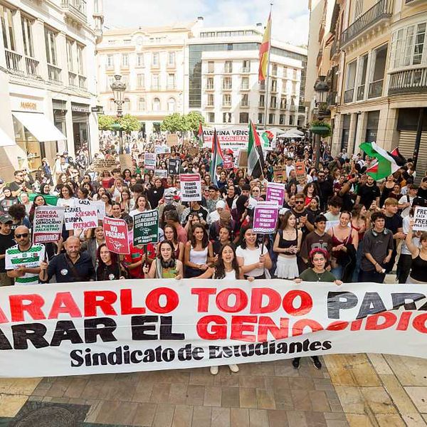 Spanish students march with a banner reading "stop everything to stop the genocide"