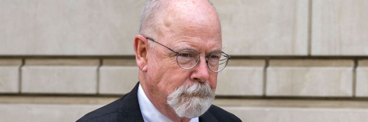 Special Counsel John Durham stands against a wall. 