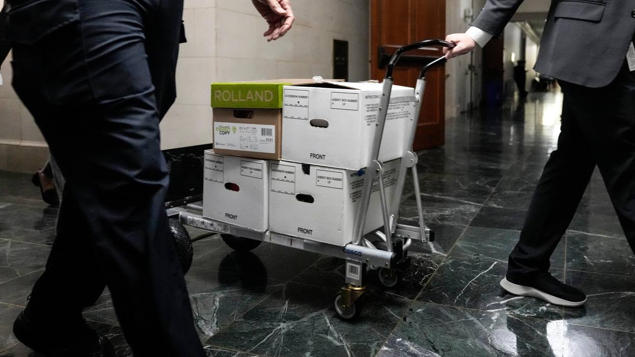 Staffers move boxes of documents from a hearing room to the office of the House Ways and Means Committee