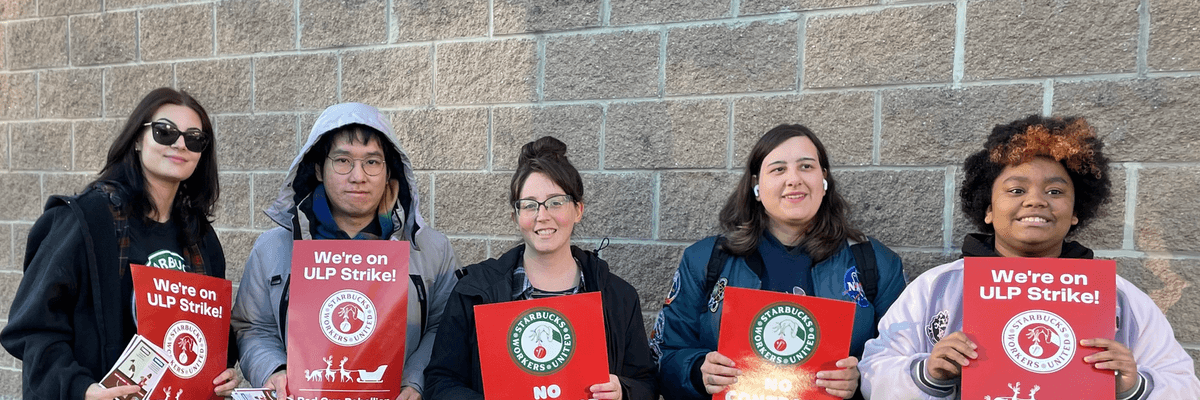 Starbucks workers hold signs reading, "No contract, no coffee"
