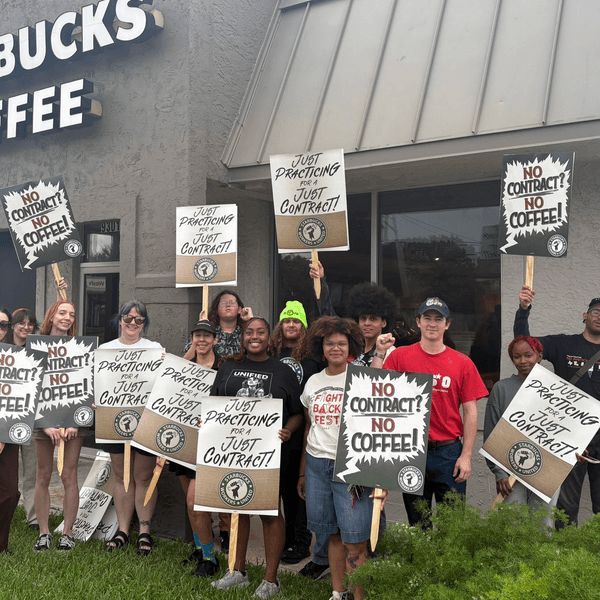 Starbucks workers hold signs reading "No contract? No coffee!"