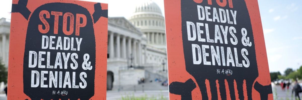 "Stop Deadly Delays and Denials" signs say