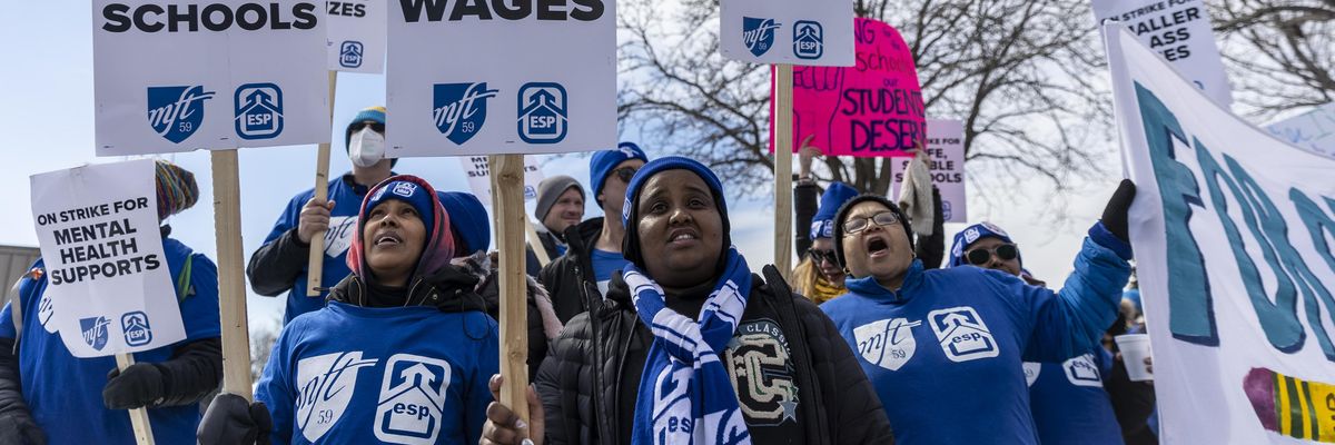 Striking Minneapolis teachers and education support professionals hold placards in front of the Justice Page Middle school in Minneapolis, Minnesota on March 8, 2022.