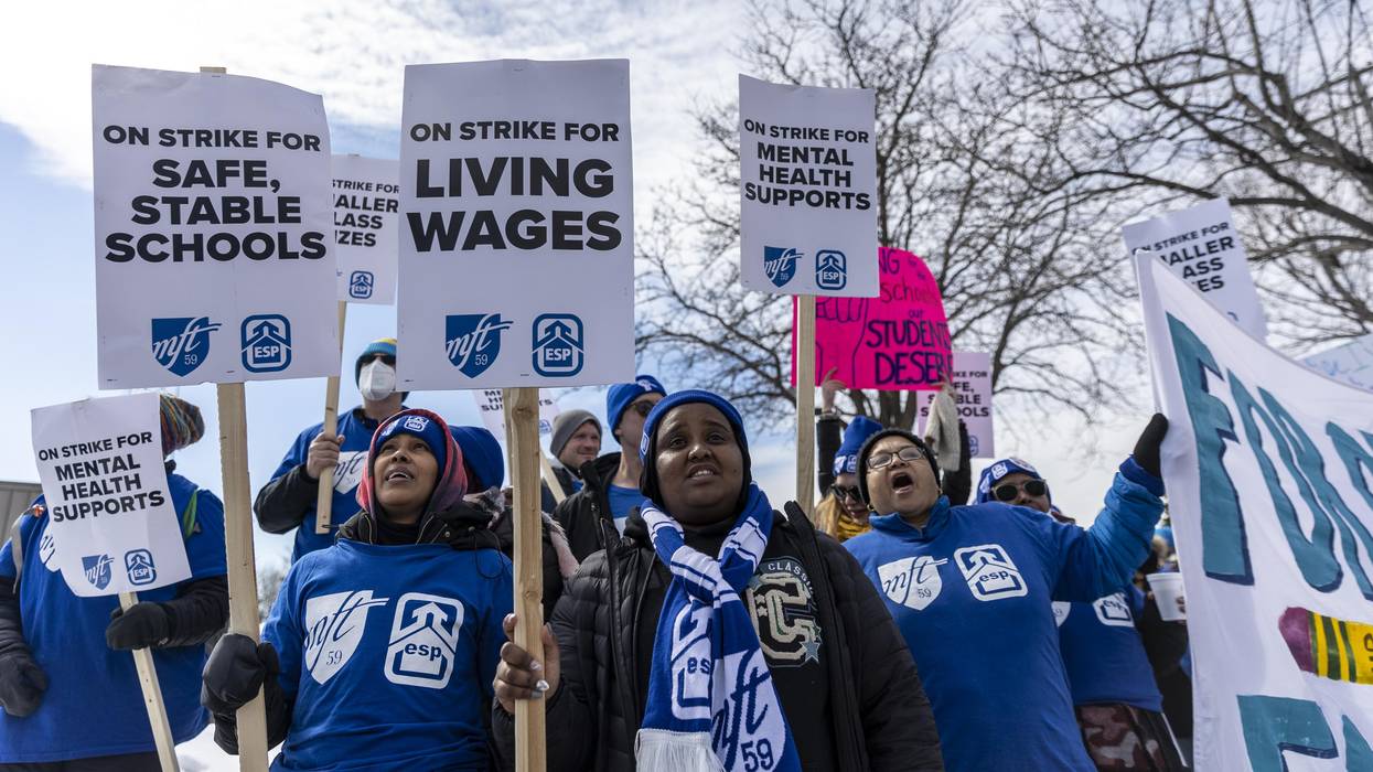 Striking Minneapolis teachers and education support professionals hold placards in front of the Justice Page Middle school in Minneapolis, Minnesota on March 8, 2022.