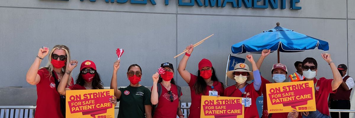 Striking nurses stand in front of a Kaiser Permanente building. 