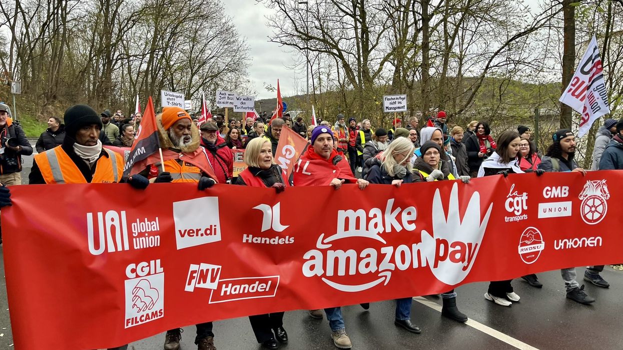 Striking workers hold a banner.