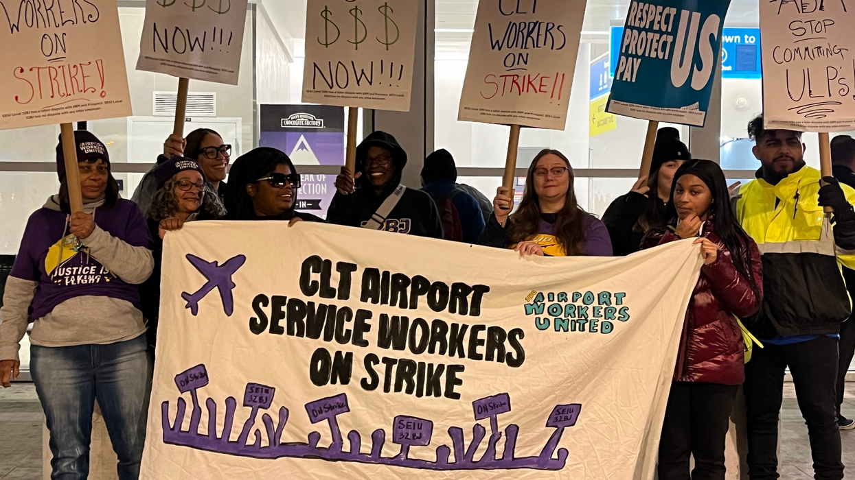 Striking workers hold a up a sign that says "CLT Airport Service Workers on Strike"