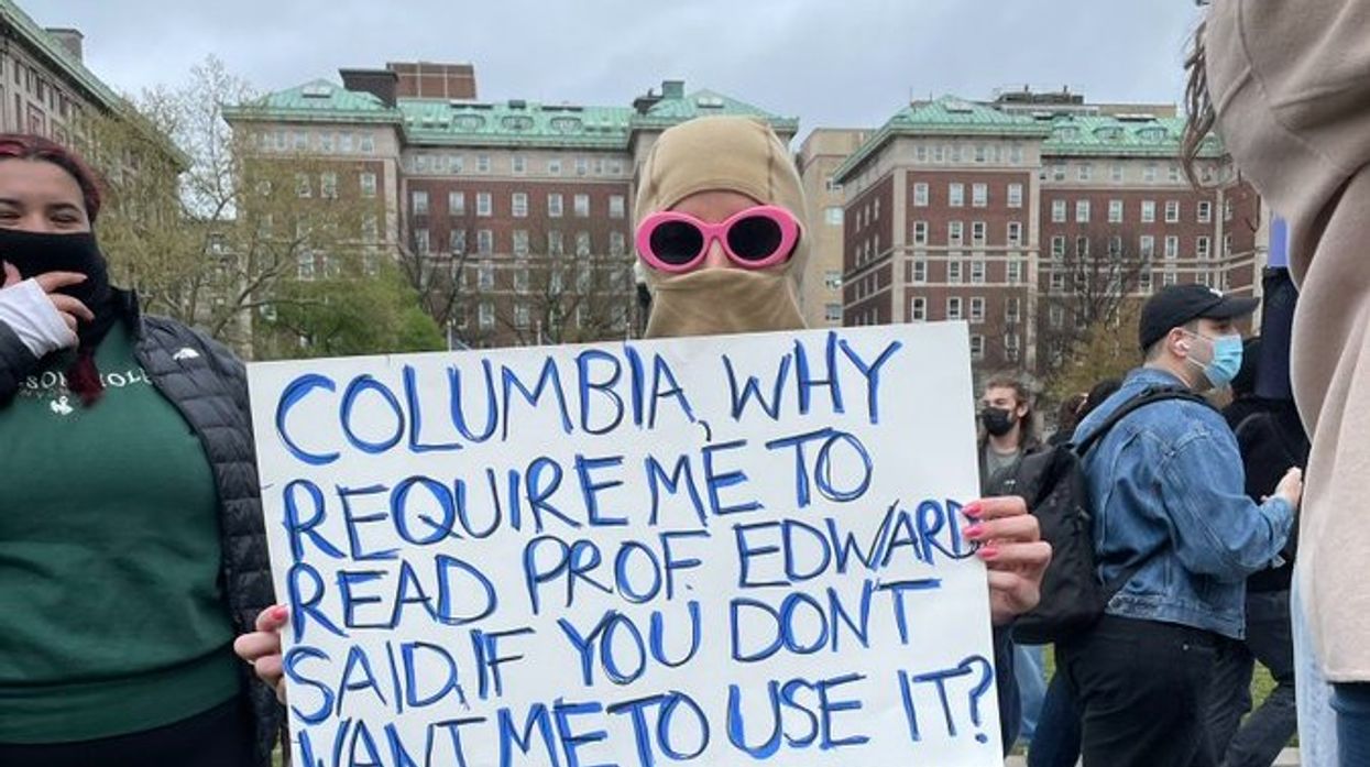 Student at Columbia holding sign reading, "Columbia, why require me to read Prof. Edward Said, if You don't want me to use it?"