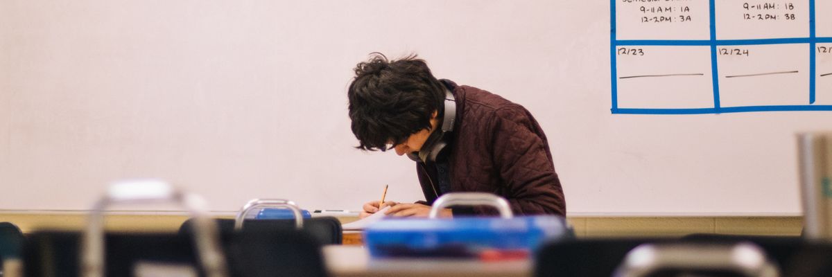 Student writing in a classroom