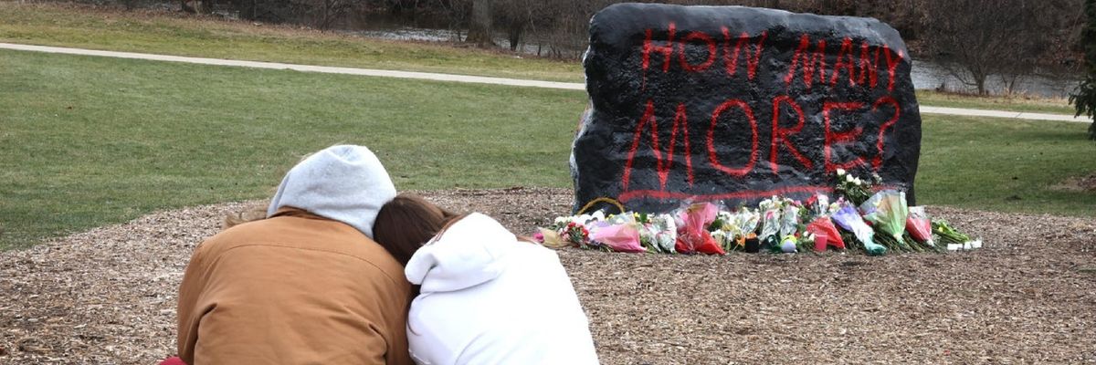Students from Michigan State University grieve at a makeshift memorial asking, "How Many More" after another school shooting.
