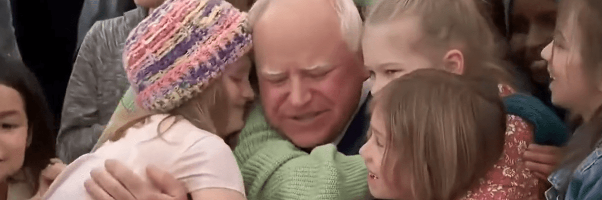 Students hug Democratic Minnesota Gov. Tim Walz after he signed a universal free school meal bill into law on March 17, 2023.