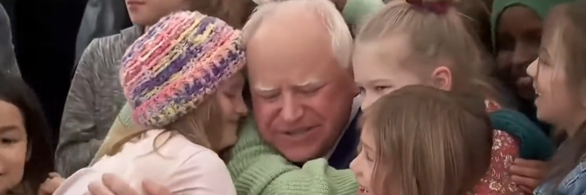 Students hug Democratic Minnesota Gov. Tim Walz after he signed a universal free school meal bill into law on March 17, 2023.