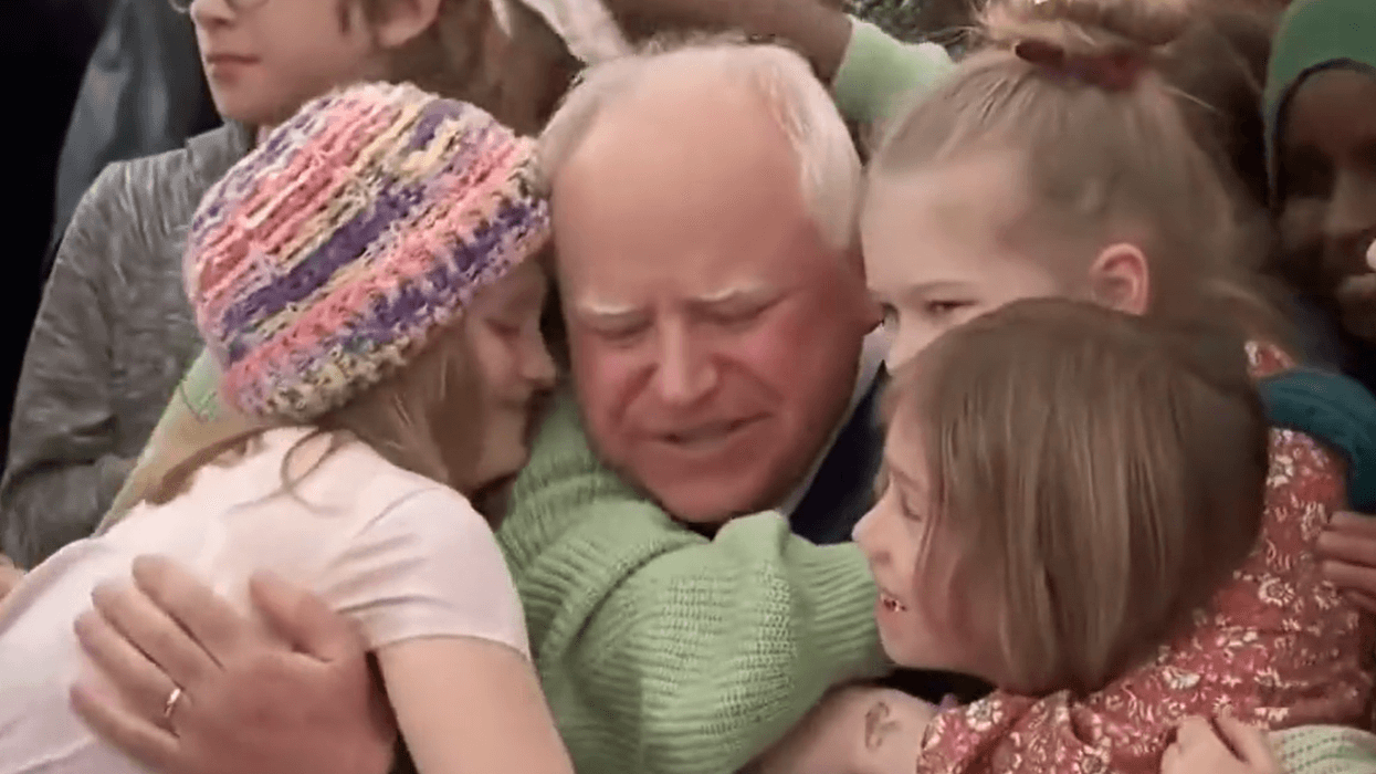 Students hug Democratic Minnesota Gov. Tim Walz after he signed a universal free school meal bill into law on March 17, 2023.