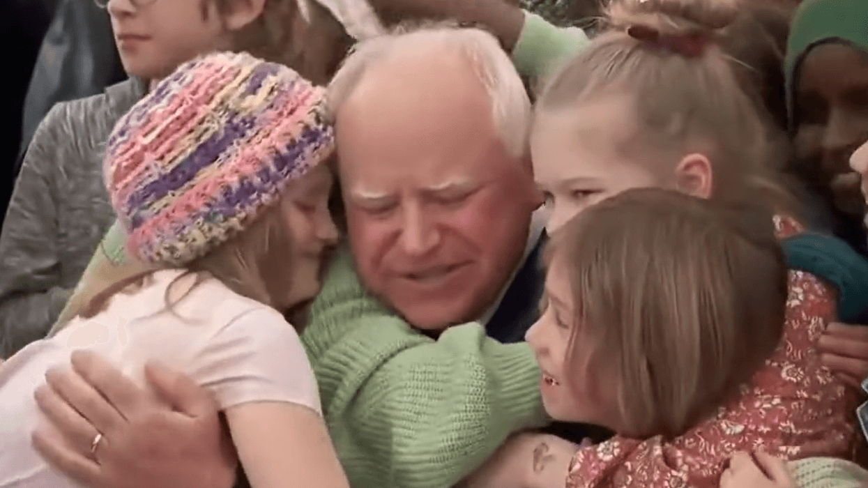 Students hug Democratic Minnesota Gov. Tim Walz after he signed a universal free school meal bill into law on March 17, 2023.