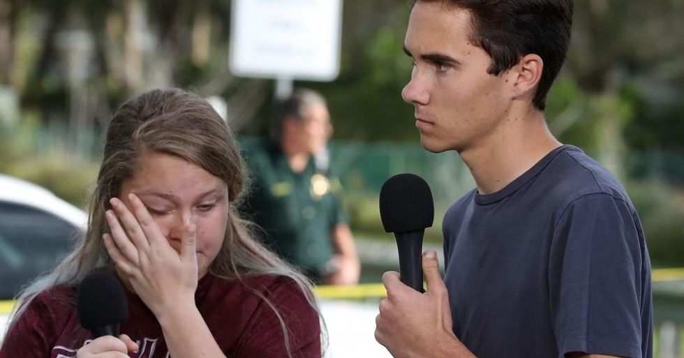 Students Kelsey Friend (L) and David Hogg recount their stories about yesterday's mass shooting at the Marjory Stoneman Douglas High School where 17 people were killed, on February 15, 2018 in Parkland, Florida. Police arrested the suspect after a short manhunt, and have identified him as 19 year old former student Nikolas Cruz. (Photo: Mark Wilson/Getty Images)