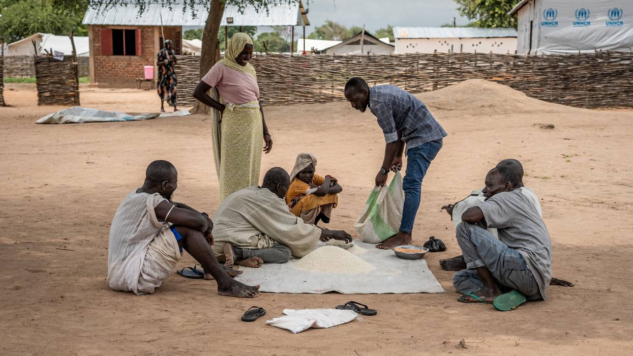 Sudanese refugees in the Korsi camp sit together around a pile of ground cassava on August 10, 2024.