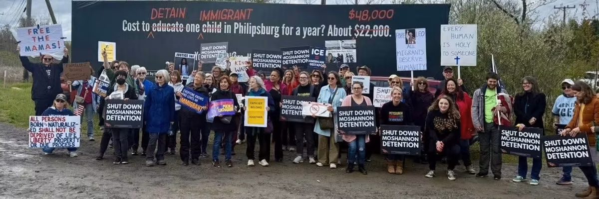Summer Lee and supporters stand with signs opposing Moshannon ICE facility.