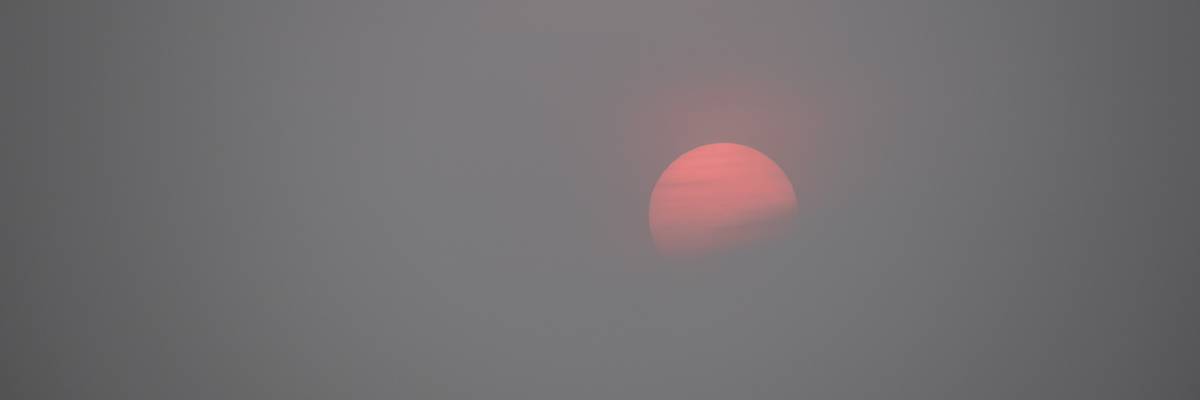 Sunset over Boston Harbor with wildfire haze.