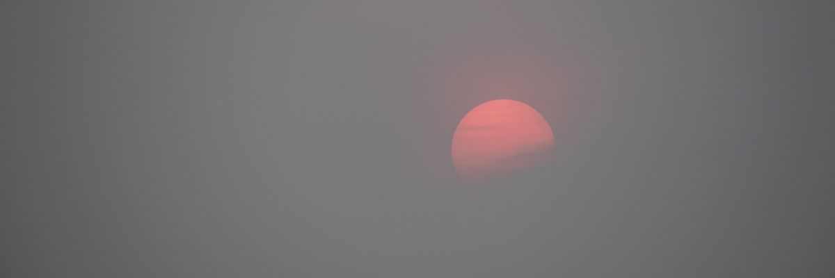 Sunset over Boston Harbor with wildfire haze.