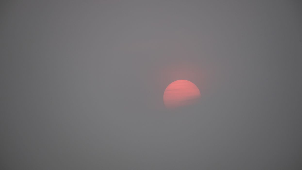 Sunset over Boston Harbor with wildfire haze.