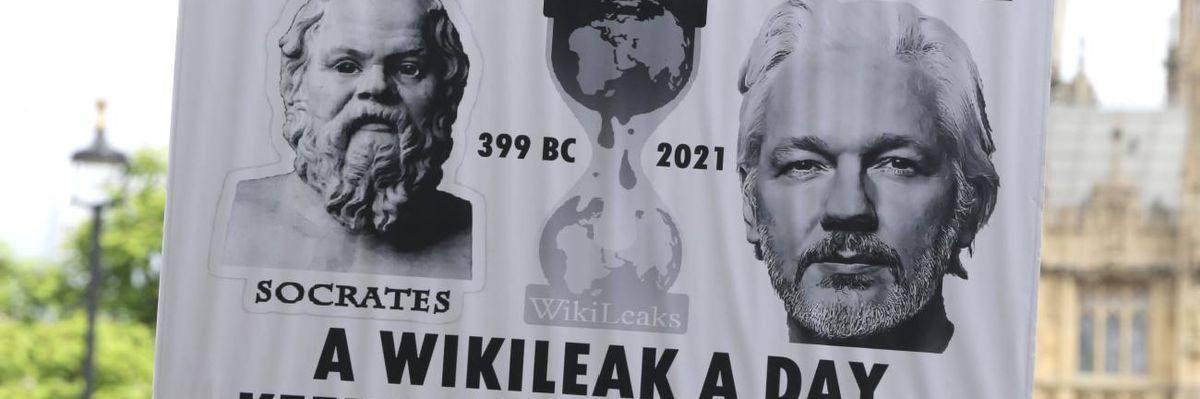Supporters carry signs calling for release of Julian Assange.