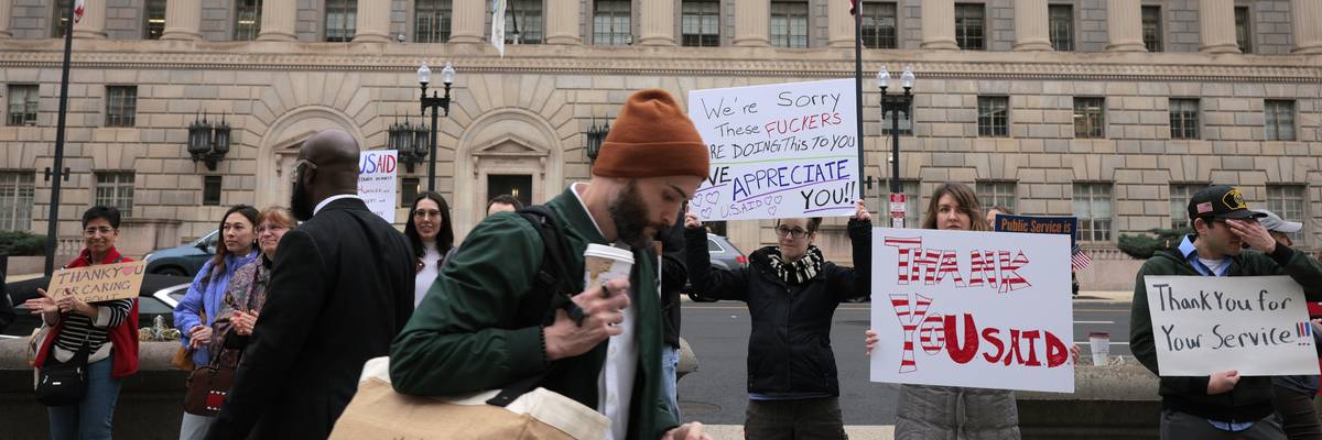 Supporters hold signs thanking USAID employees