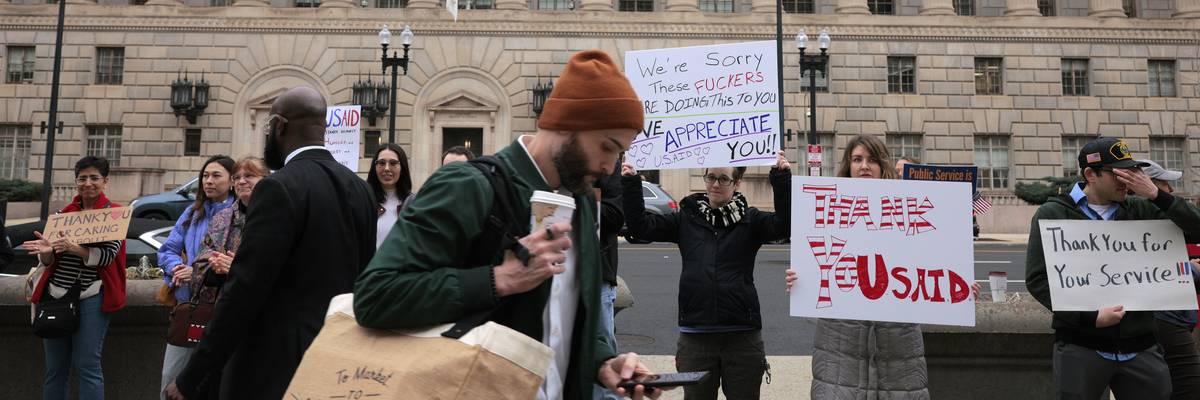 Supporters hold signs thanking USAID employees