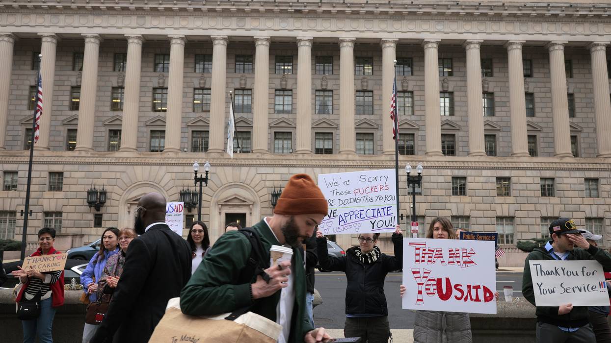 Supporters hold signs thanking USAID employees