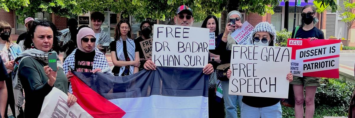 supporters hold signs that say "Free Dr. Badar Khan Suri"