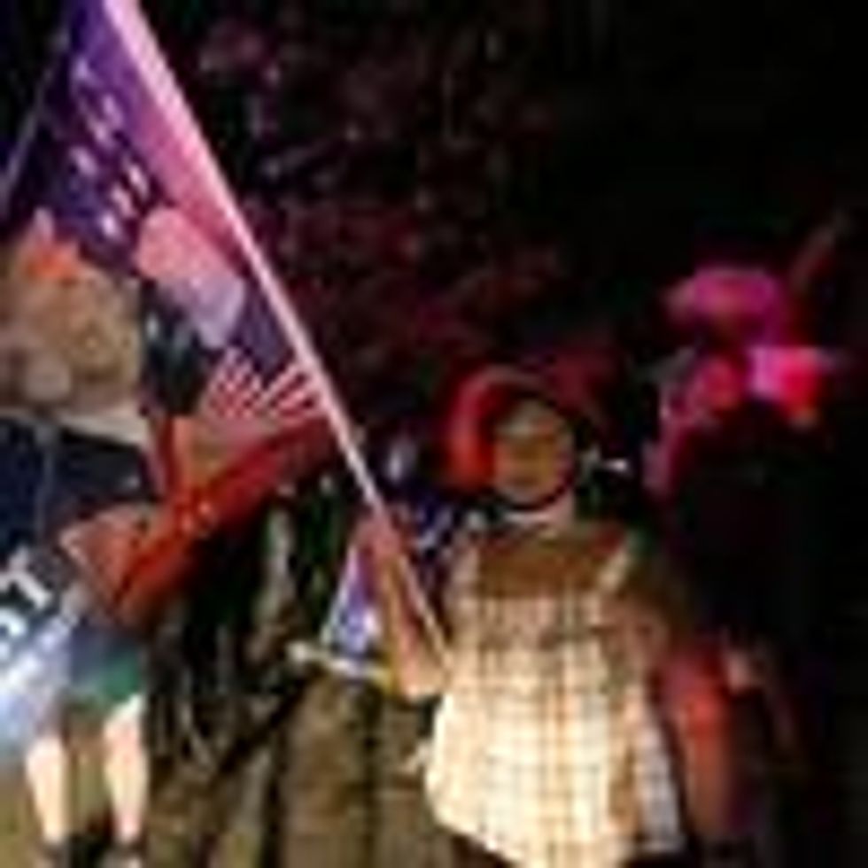 Supporters of former President Donald Trump hold flags in front of his home at Mar-a-Lago on August 8, 2022 in Palm Beach, Florida.