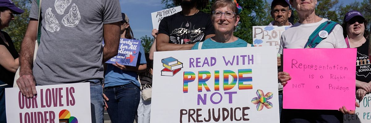Supporters of LGBTQ+ rights hold signs as they demonstrate outside the U.S. Supreme Court