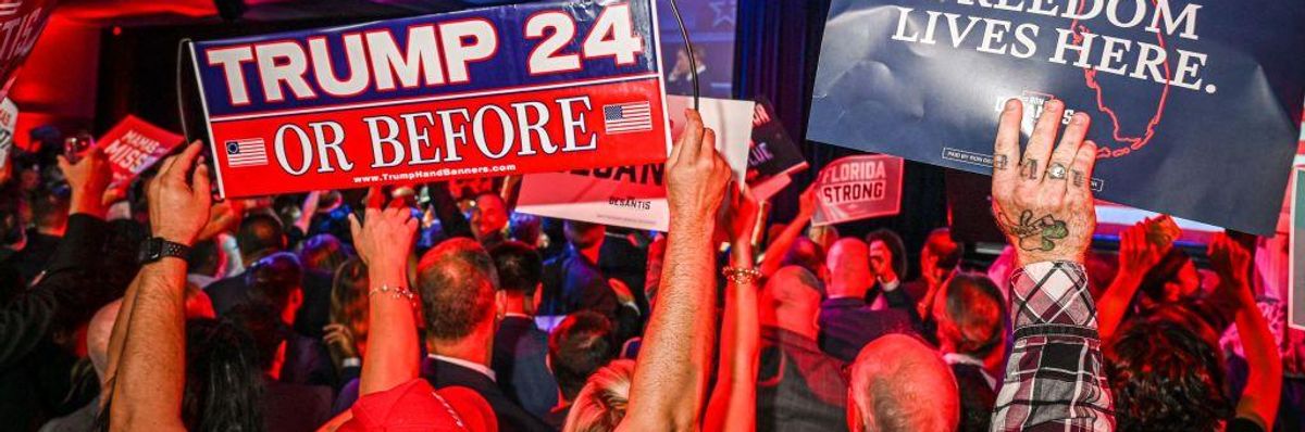 Supporters of Republican gubernatorial candidate for Florida Ron DeSantis cheer with Trump signs